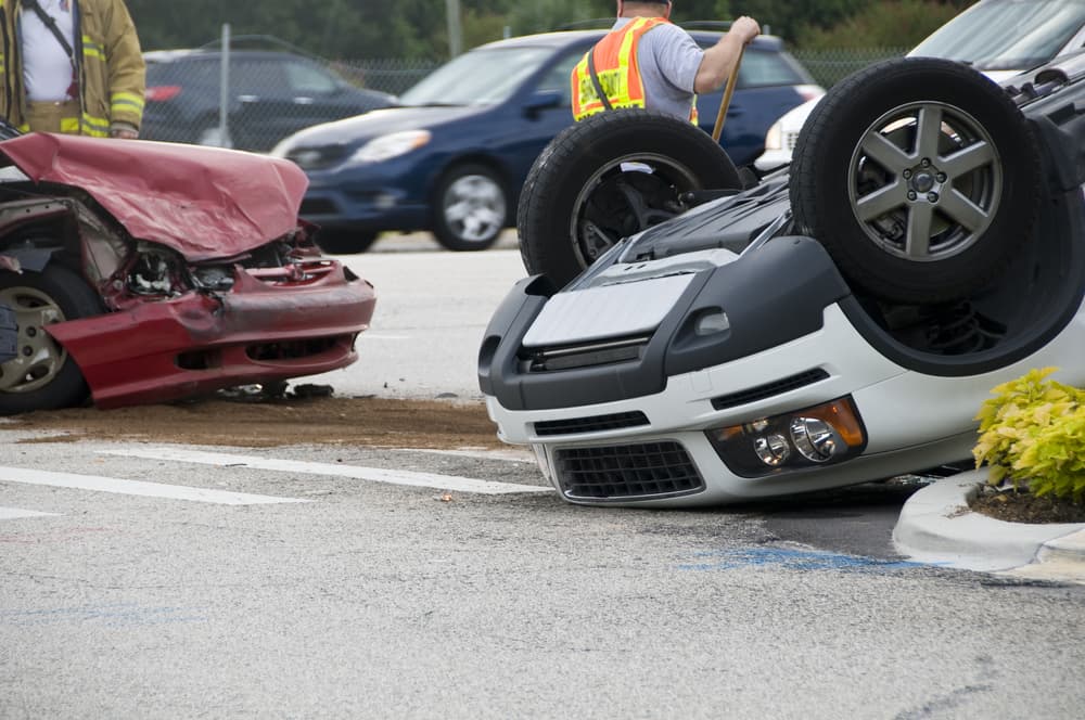 Emergency responders at the scene of a rollover vehicle accident at a busy intersection, providing assistance and managing the situation.