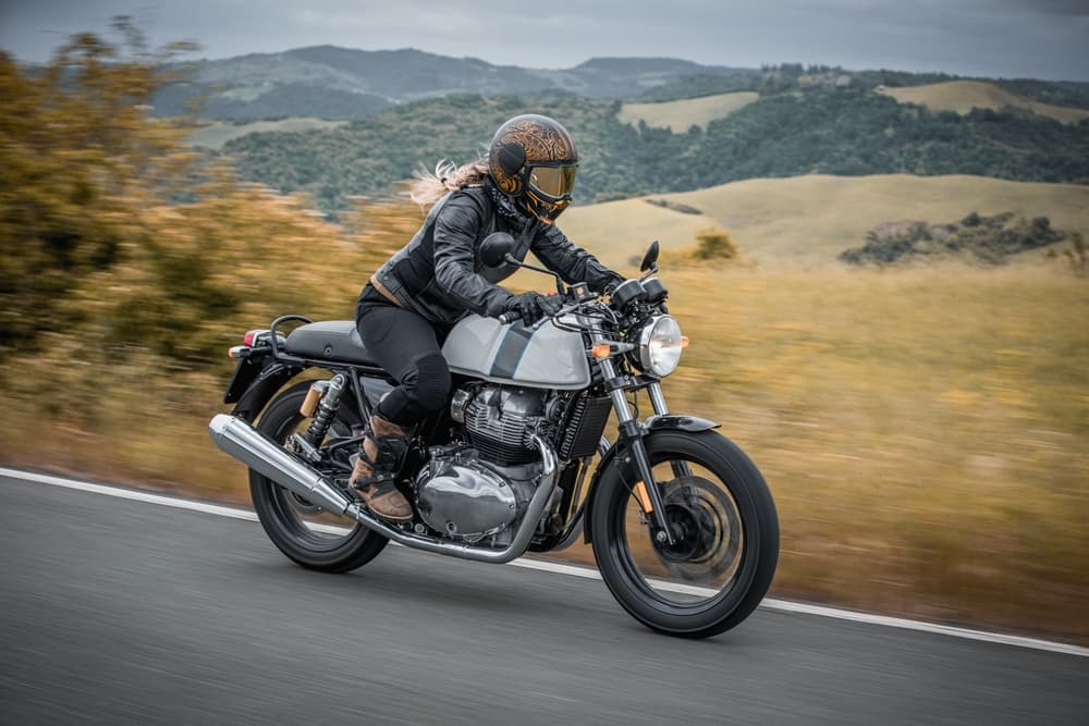 A woman riding a classic motorcycle, exuding confidence and style.