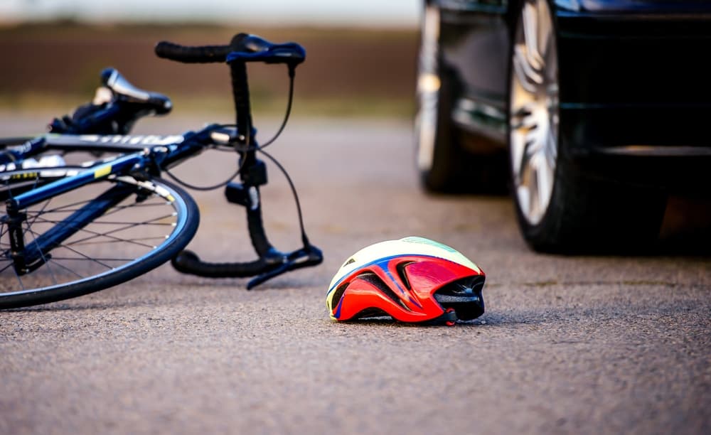 Traffic accident scene – A bicycle and helmet lie on the road after a car collided with a cyclist.