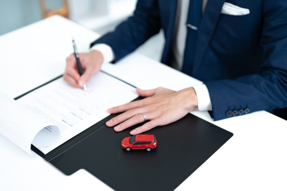 A man writing car-related documents in the office