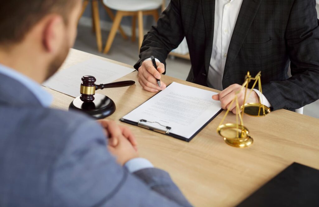Car Accident Lawyer Consultation After Intersection Accident Client consulting with car accident lawyer in office reviewing legal documents after intersection crash
