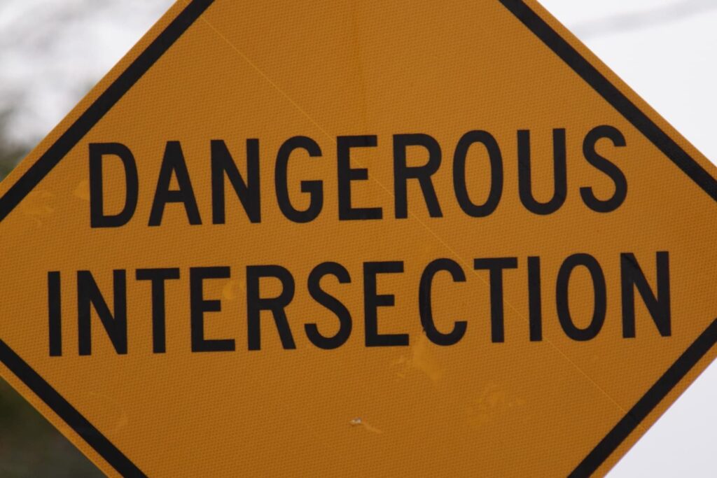 Dangerous Intersection Warning Sign at High-Risk Road Crossing Yellow diamond warning sign reading “Dangerous Intersection” indicating high-risk roadway crossing