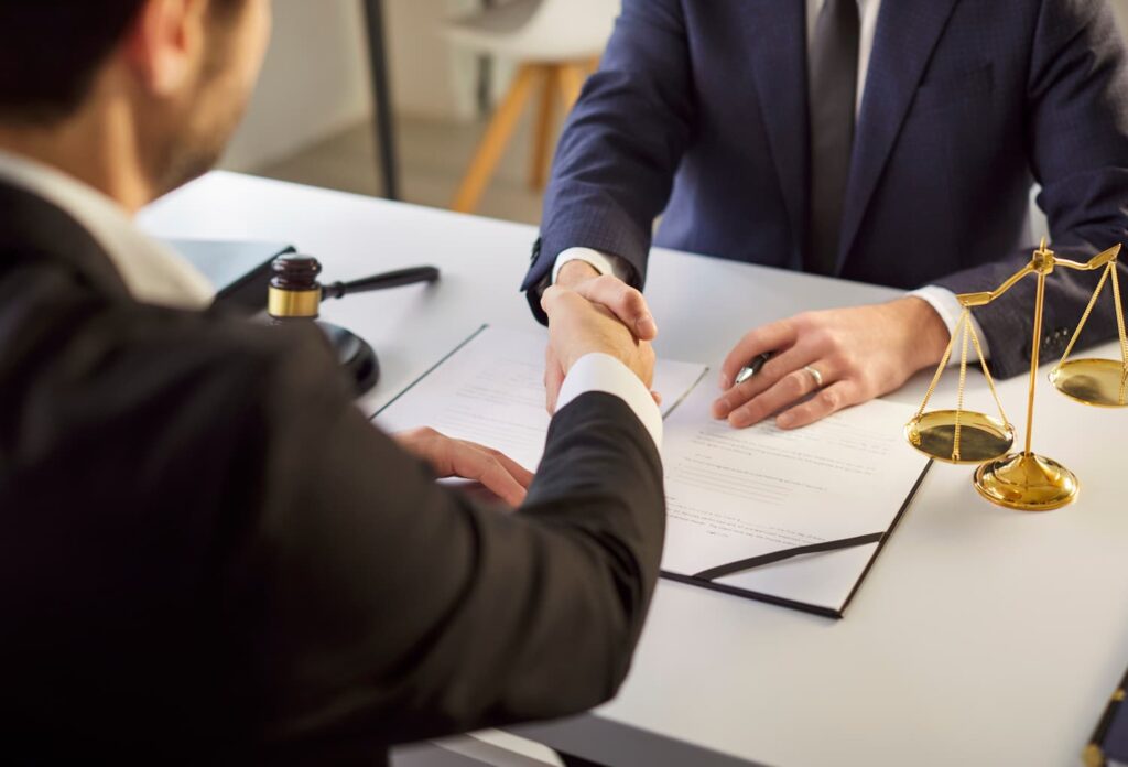 Motorcycle Crash Lawyer Helping Fight Helmet Defense in Injury Claims motorcycle accident lawyer consultation handshake helmet defense injury claim New York legal strategy meeting